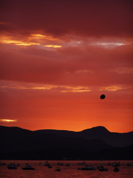 Balloon floating in front of mountains at sunset